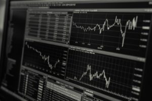 Pantalla de computadora mostrando una plataforma de trading con gráficos de velas y líneas de precios para EURUSD y oro, junto a una lista de cotizaciones y datos de mercado.
